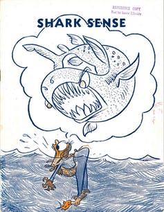 Cover depicting a cartoon shark about to attack someone stranded in the ocean.