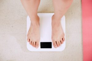 4 ways you can change your relationship with exercise woman stood on scales
