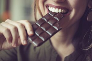 Anxious or stressed 10 healthy foods you should probably avoid woman eating dark chocolate.