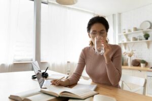 woman working from home drinking water