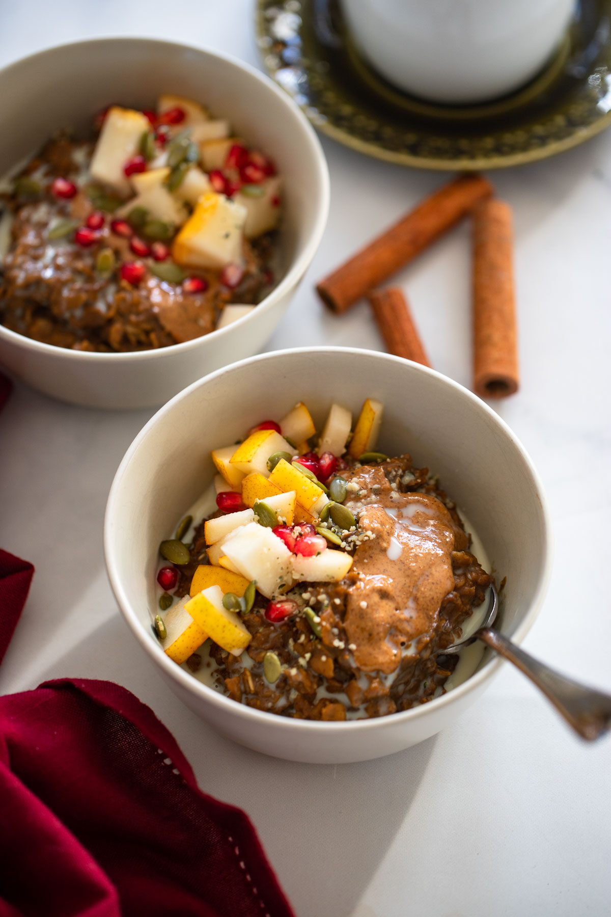 gingerbread oatmeal topped with melty almond butter, chopped pears, and pomegranate.