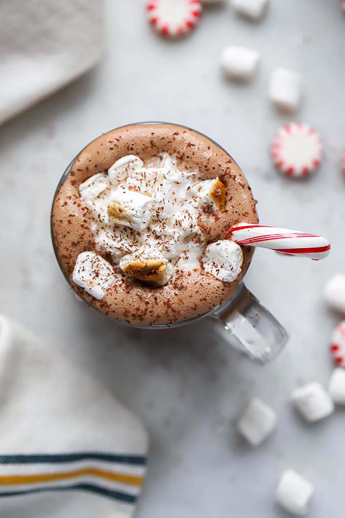 peppermint hot chocolate in mug with toasted mini marshmallows and candy cane.