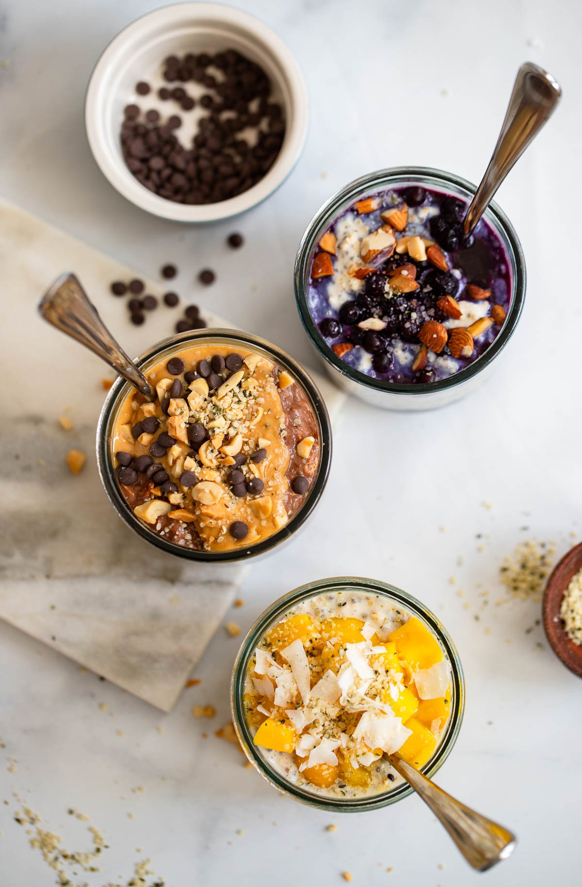 3 jars of overnight oats with different flavors like blueberry and chocolate peanut butter.