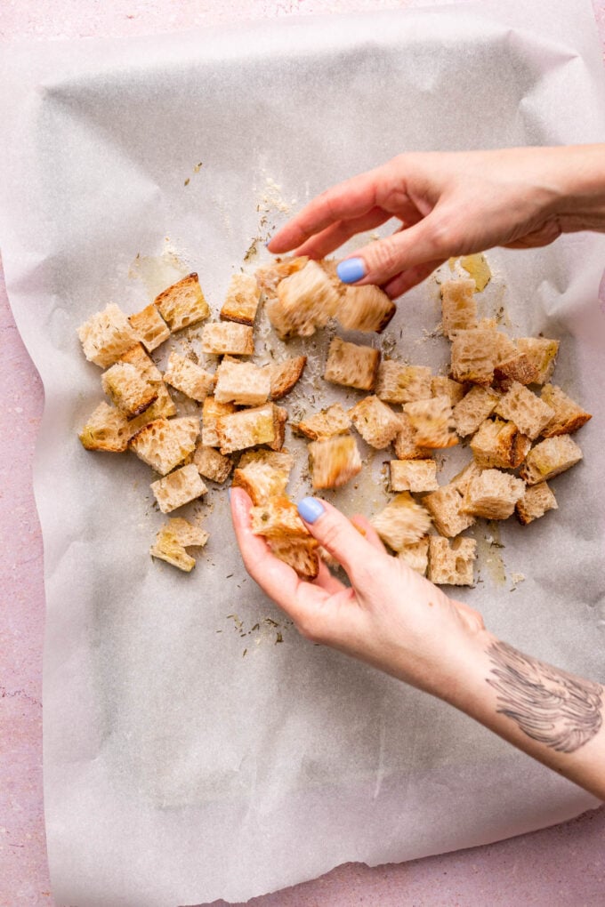 hand tossing homemade croutons