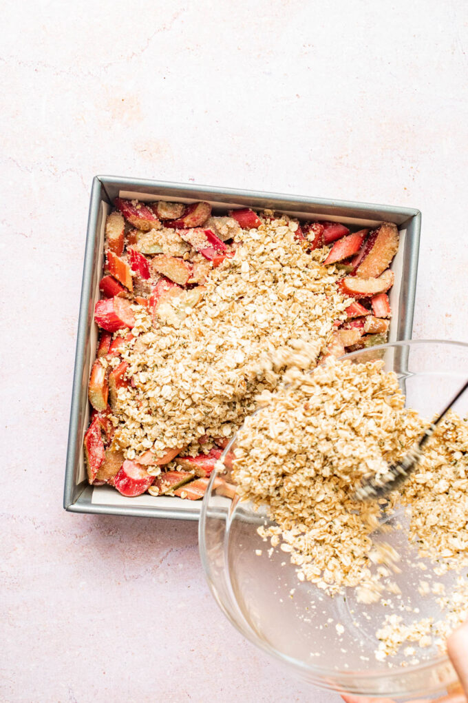 pouring oats onto pan of rhubarb