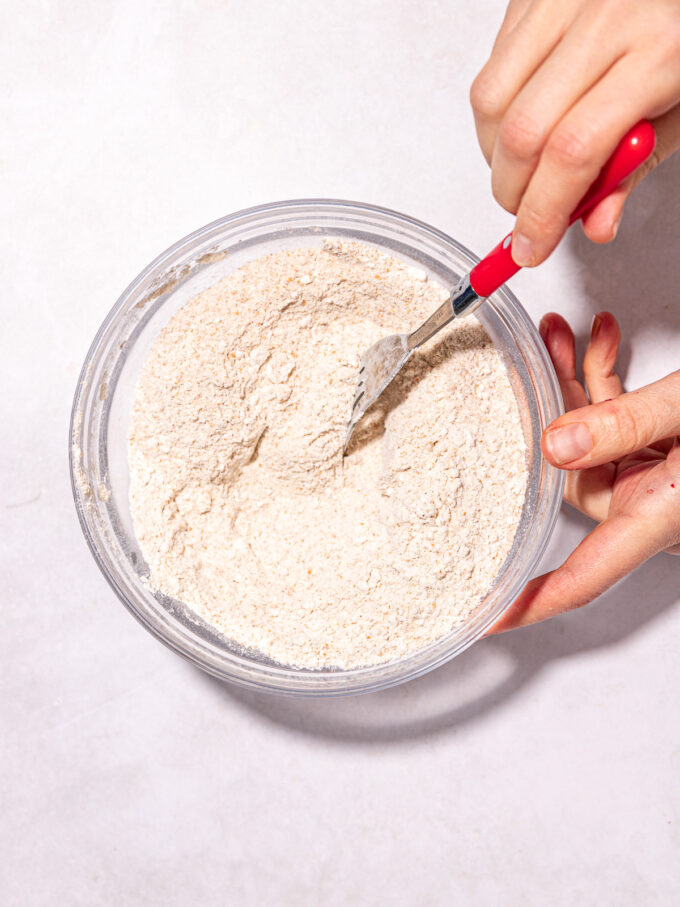 hand stirring flour in bowl