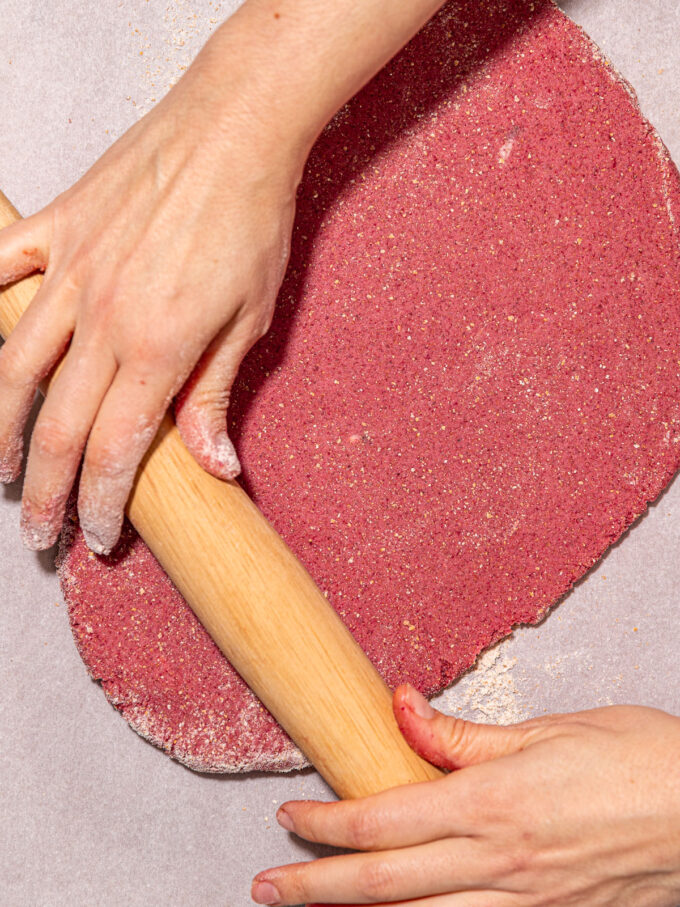 hands rolling pink cookie dough